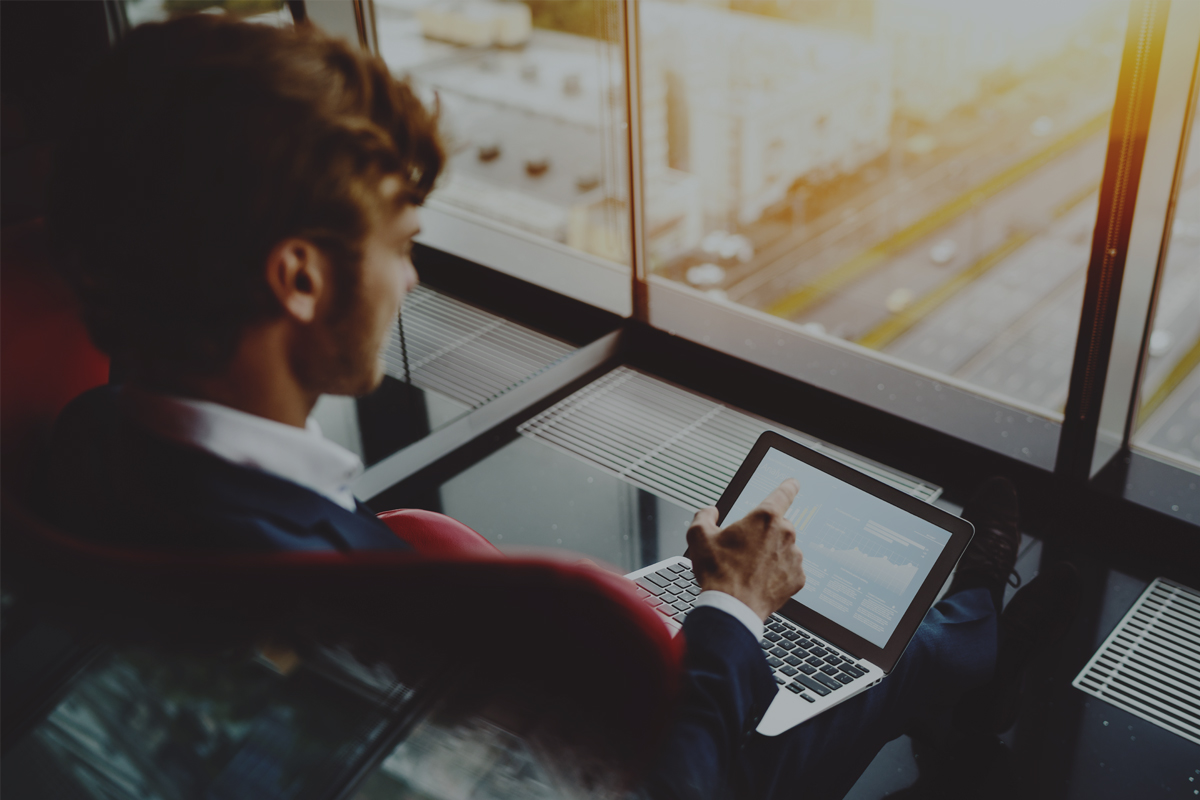 Man in high-rise building using laptop