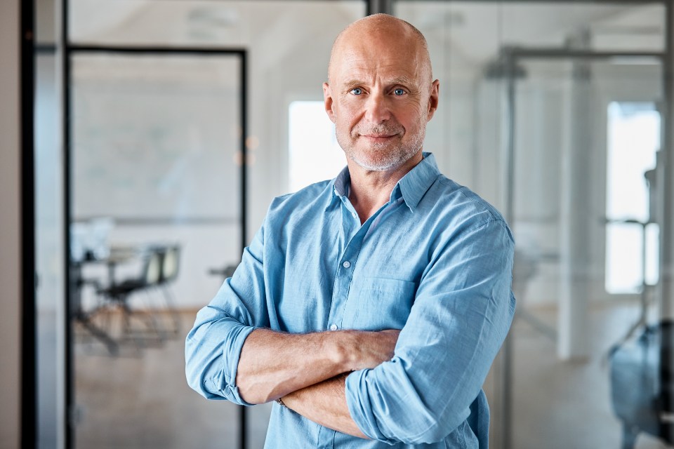 Mature professional man standing in office