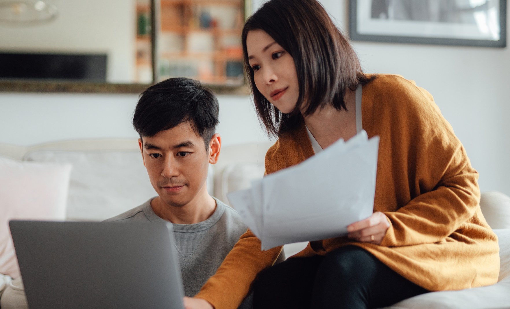 Couple looking at screen and documents