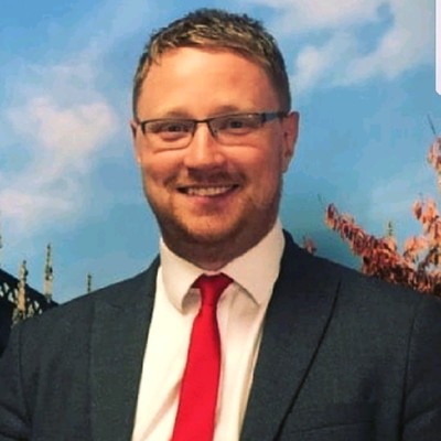 Professional male teacher in office smiling with crossed arms