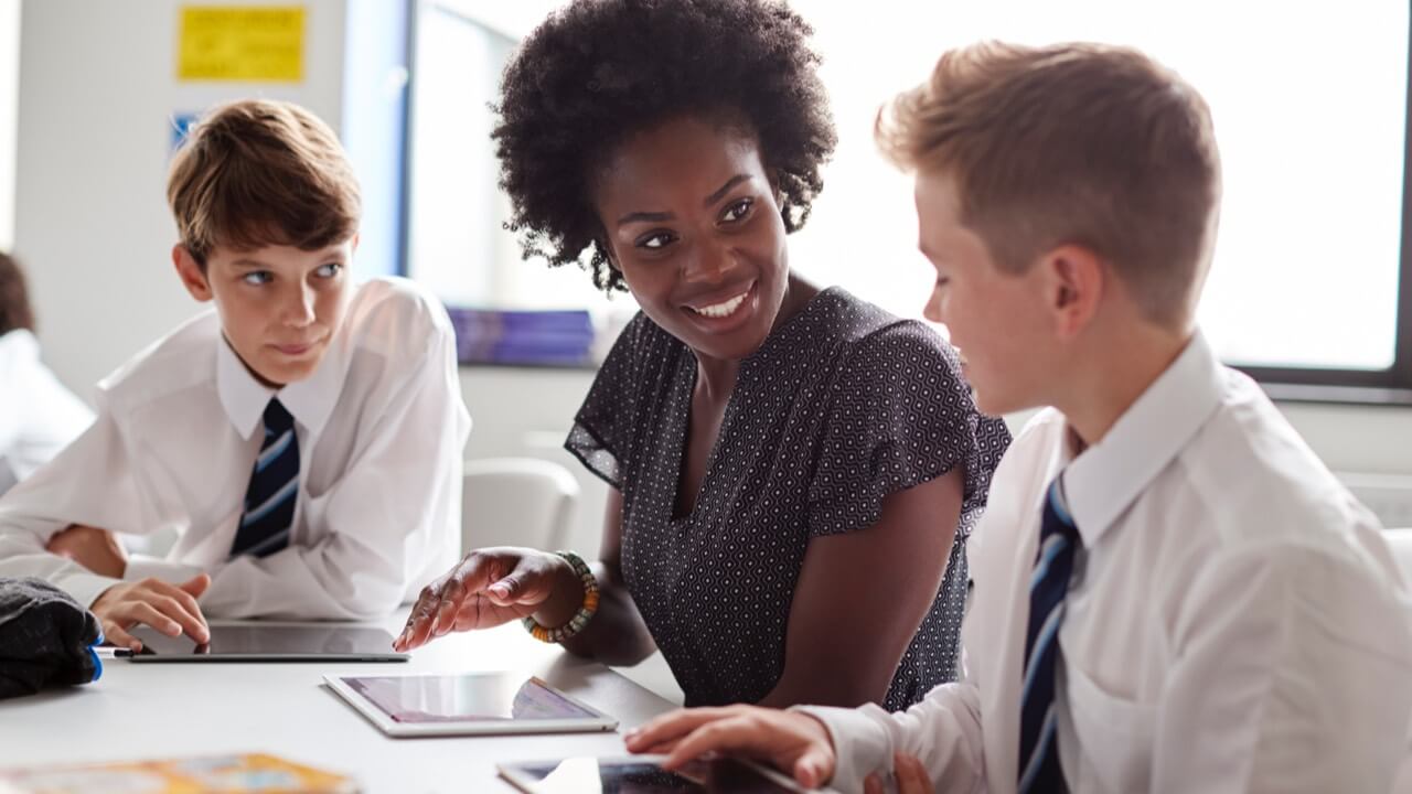 Young female teacher talking with pupils