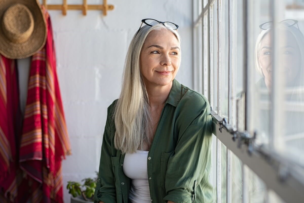 Mature woman smiling looking out window