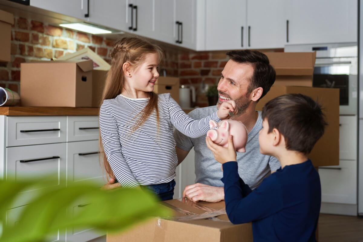 Father with young children moving boxes in home