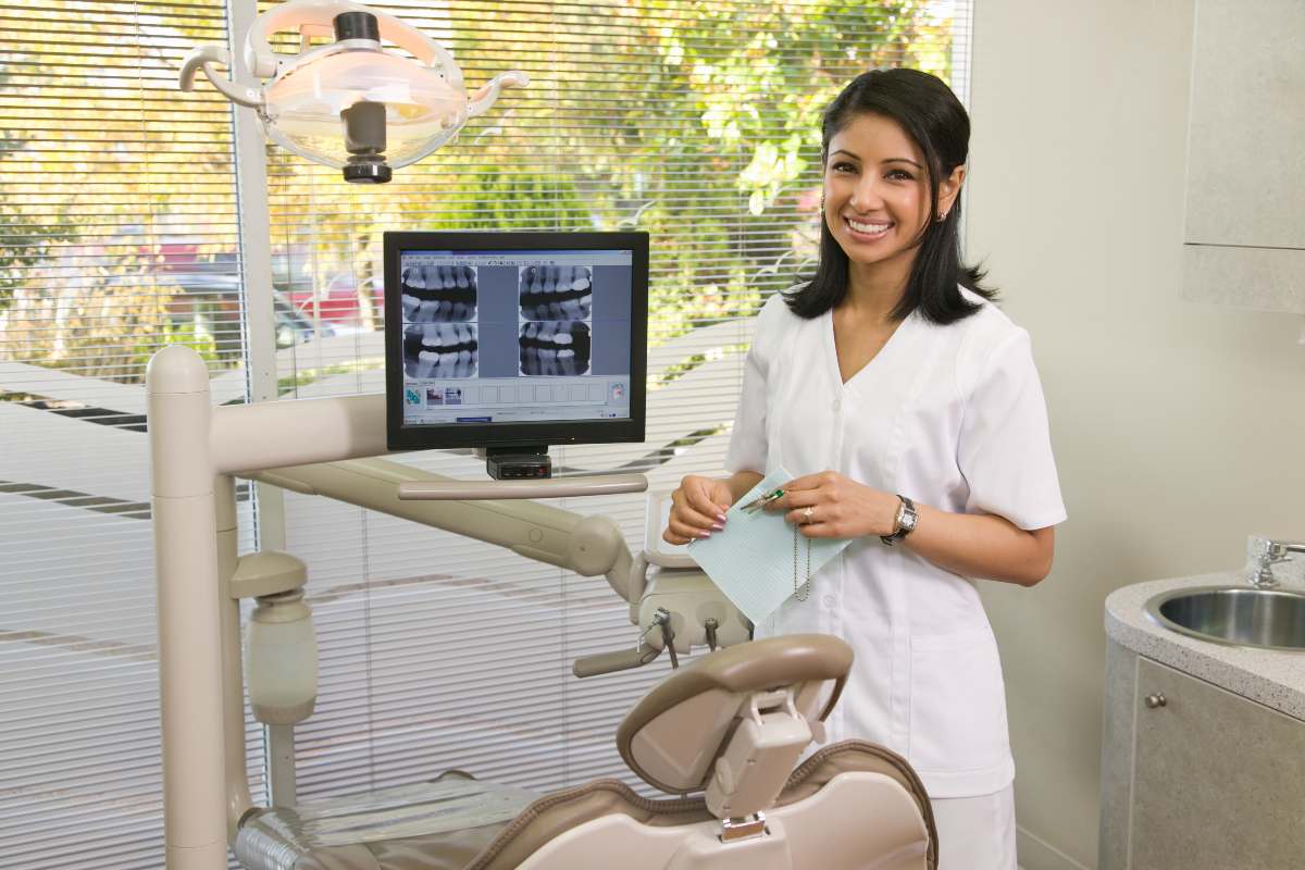 Female dentist standing next to scan smiling