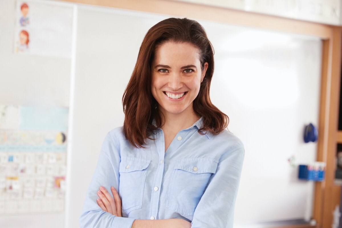 Female teacher smiling in front of whiteboard