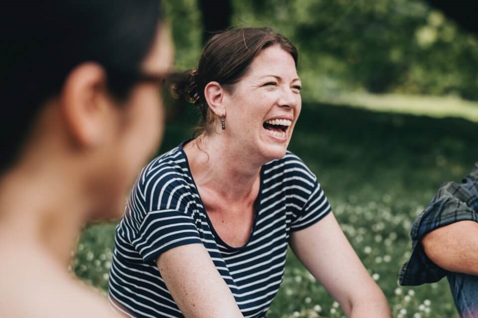 Laughing woman sitting outdoors