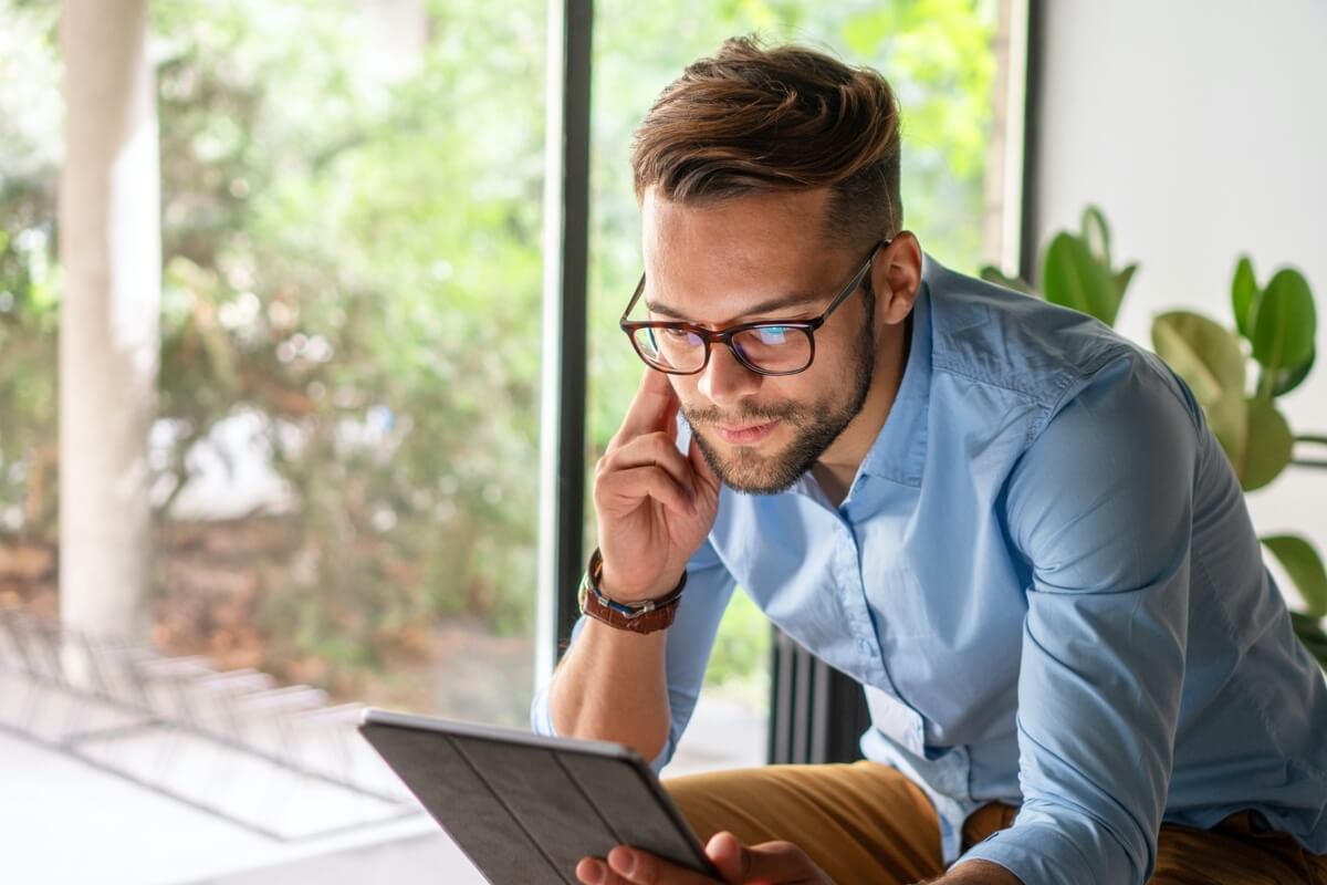 Man with glasses looking at ipad