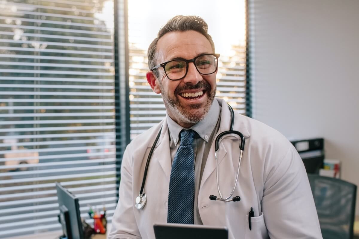 Mature male doctor with glasses in office