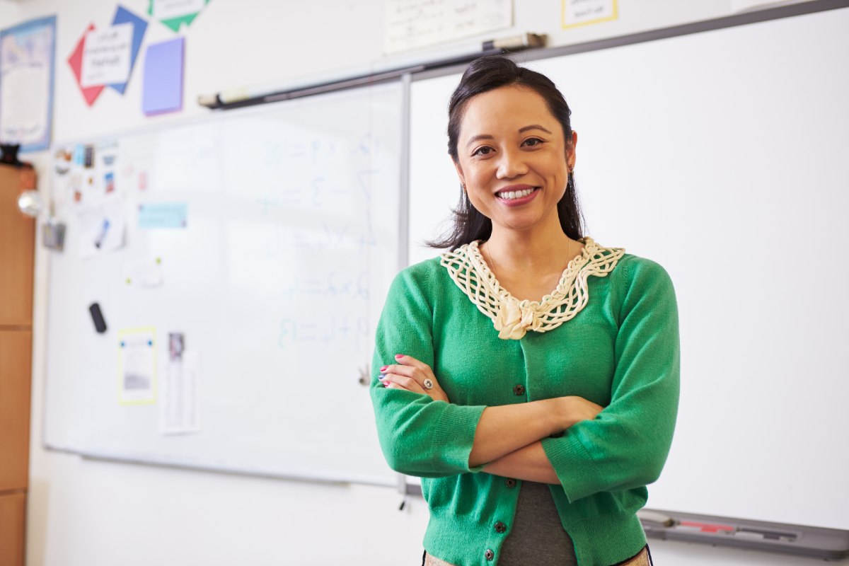 Female teacher standing in front of whiteboard Female teacher standing in front of whiteboard