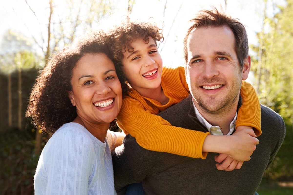 Young family smiling outdoors