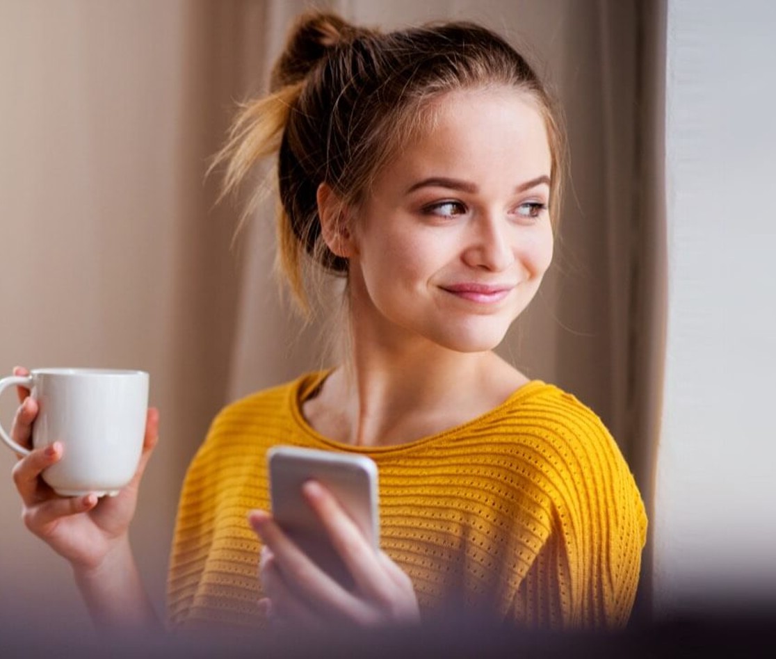 Young female smiling and holding mug