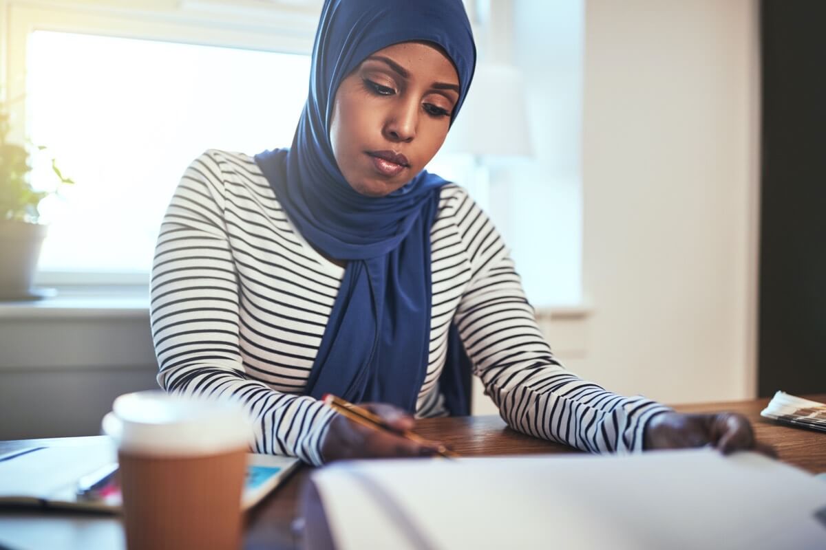 Woman wearing headscarf reading documents