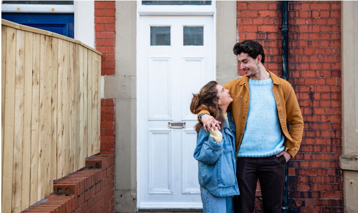 Couple smiling at each other outside their home