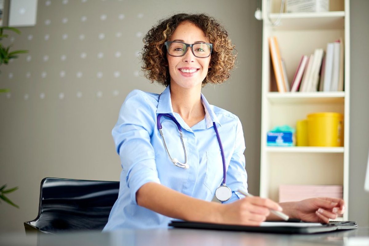 Female medical professional at desk holding pen