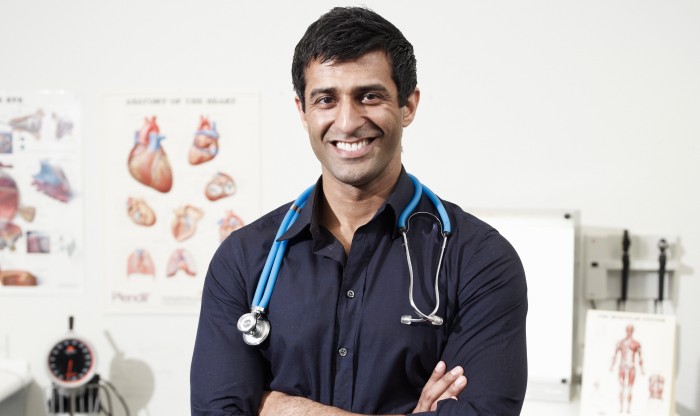 Male doctor in office smiling at camera