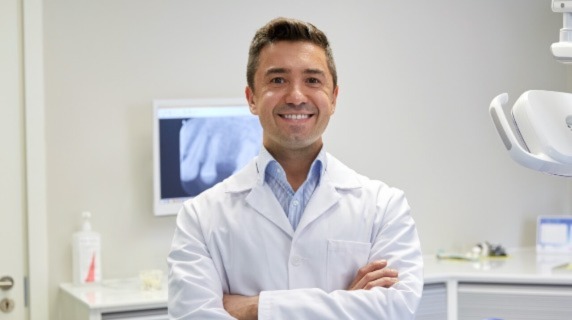 Professional male dentist smiling in clinic