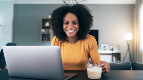 Woman smiling sitting at breakfast bar on laptop