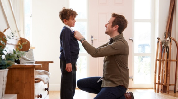 Father and son standing in home entrance hall