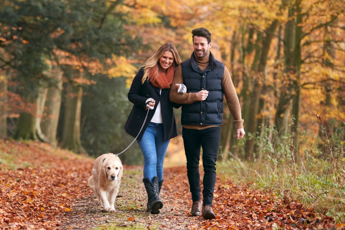 Young couple walking dog