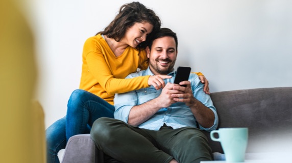 Couple on sofa looking at phone