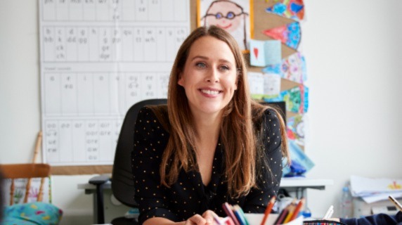 Female teacher sitting at classroom table