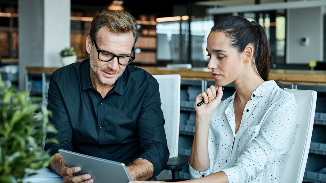 Professional man and woman reviewing document in office