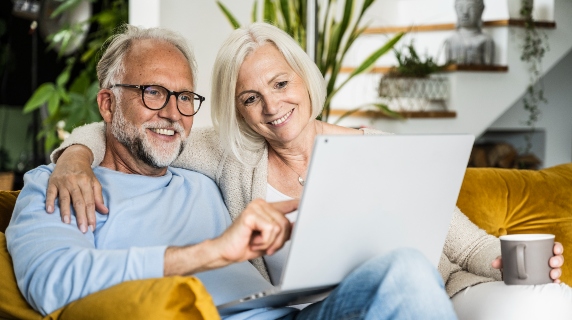 Mature couple on sofa using tablet