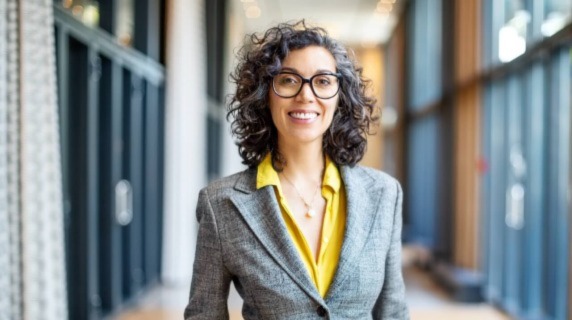 Mature lady wearing glasses standing in building corridor