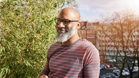 Mature man in glasses standing on balcony