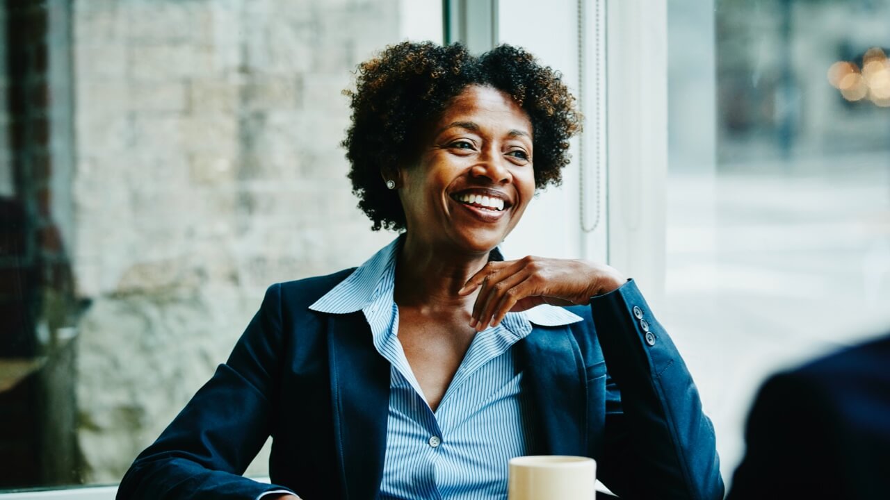 Mature professional woman smiling in office canteen