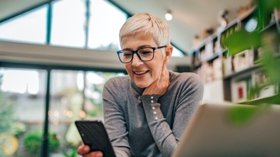 Mature woman smiling at phone