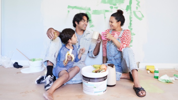 Parents with child in overalls decorating home