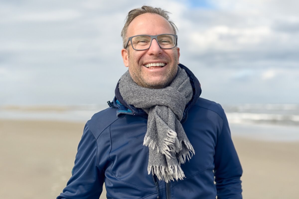 Smiling man on cold beach