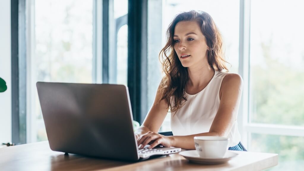 Woman on laptop with coffee