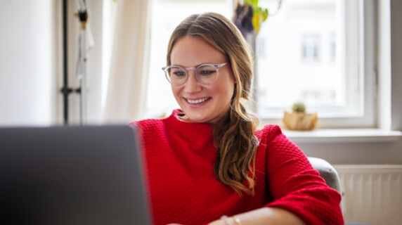 Young woman in red jumper on laptop