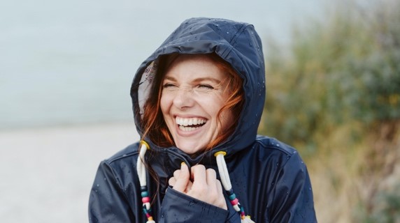 Young woman smiling in rain