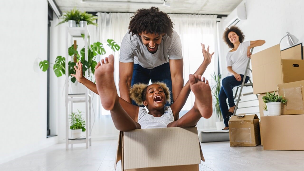 Father pushing daughter in cardboard box