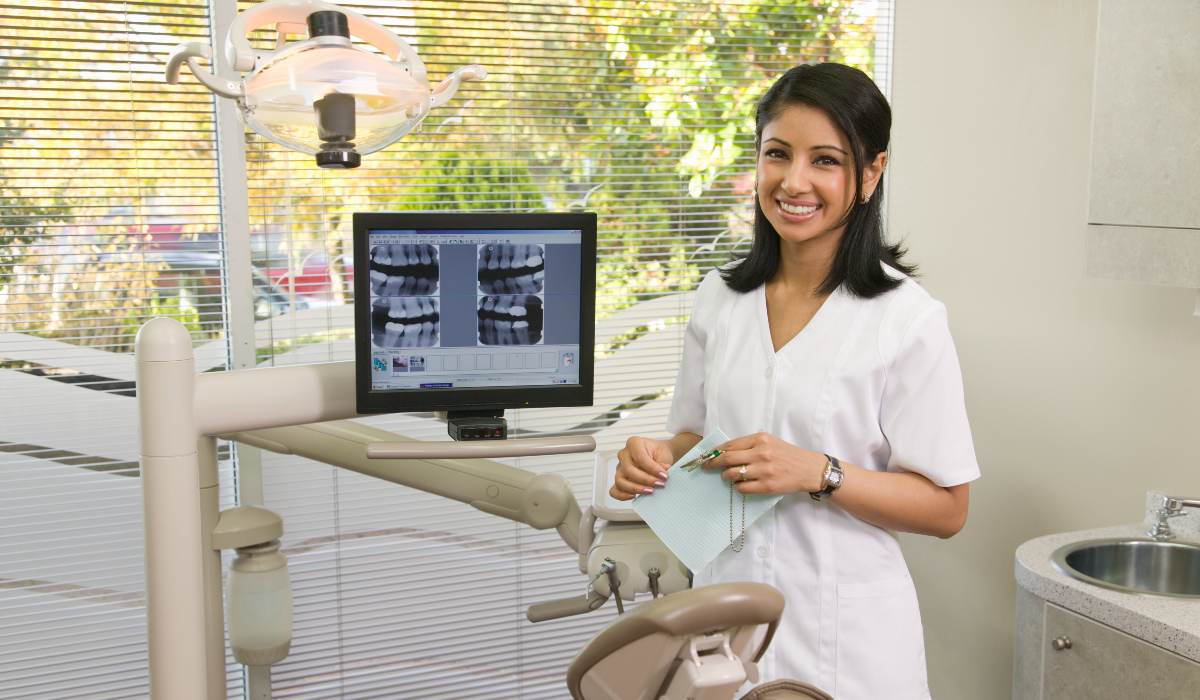 Female dentist standing next to teeth scan