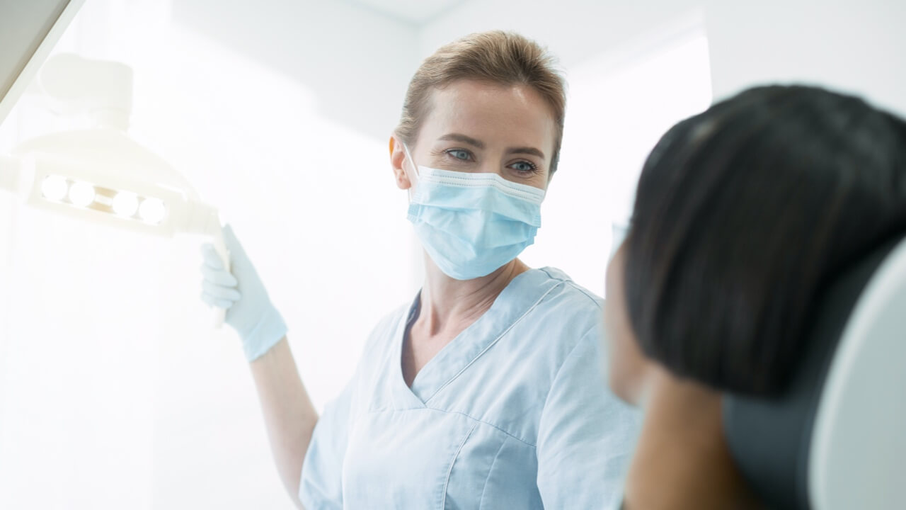 Female dentist with patient in chair