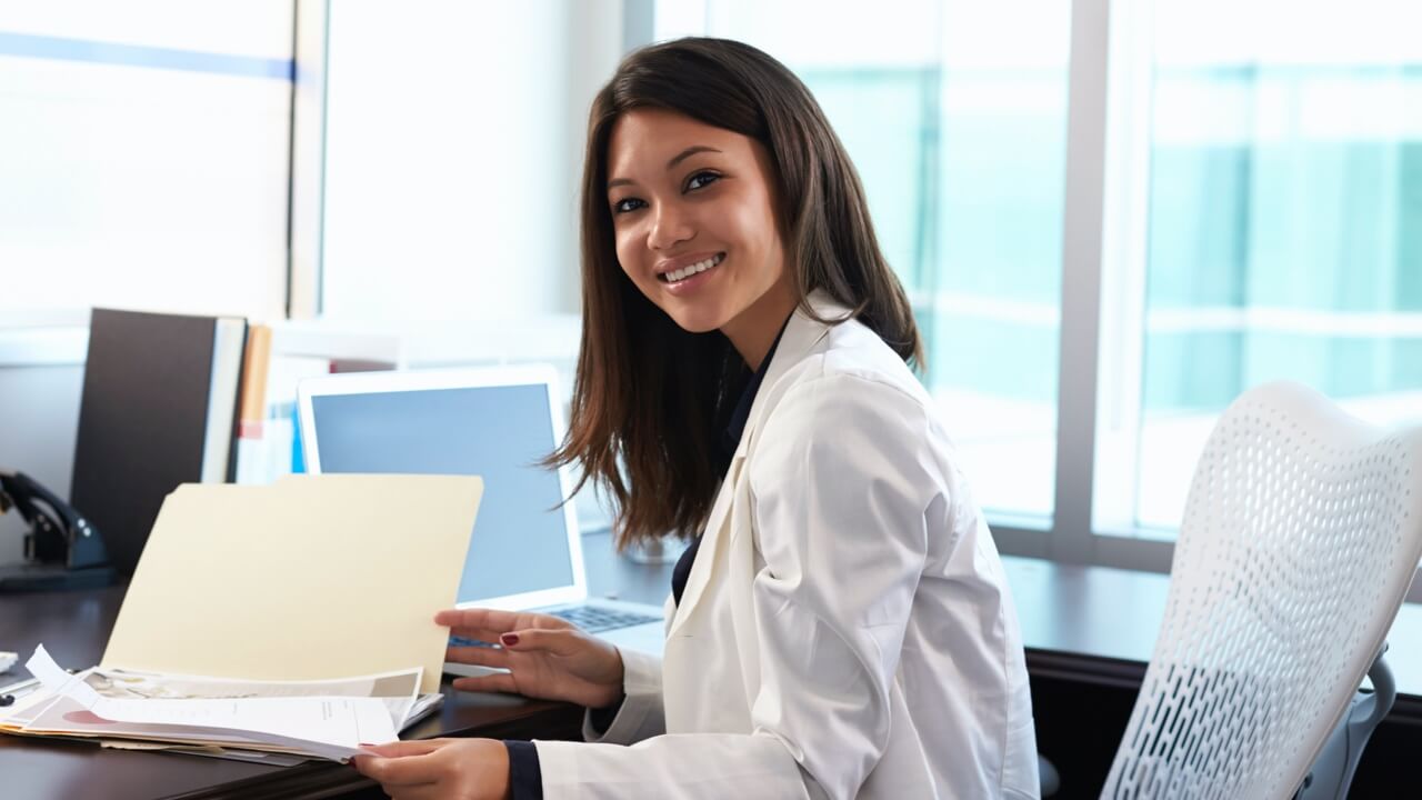 Female gp in office looking at paperwork