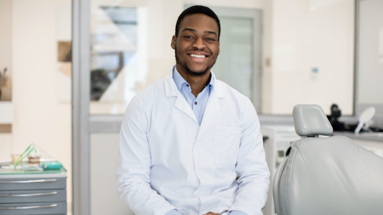 Happy male dentist in overalls