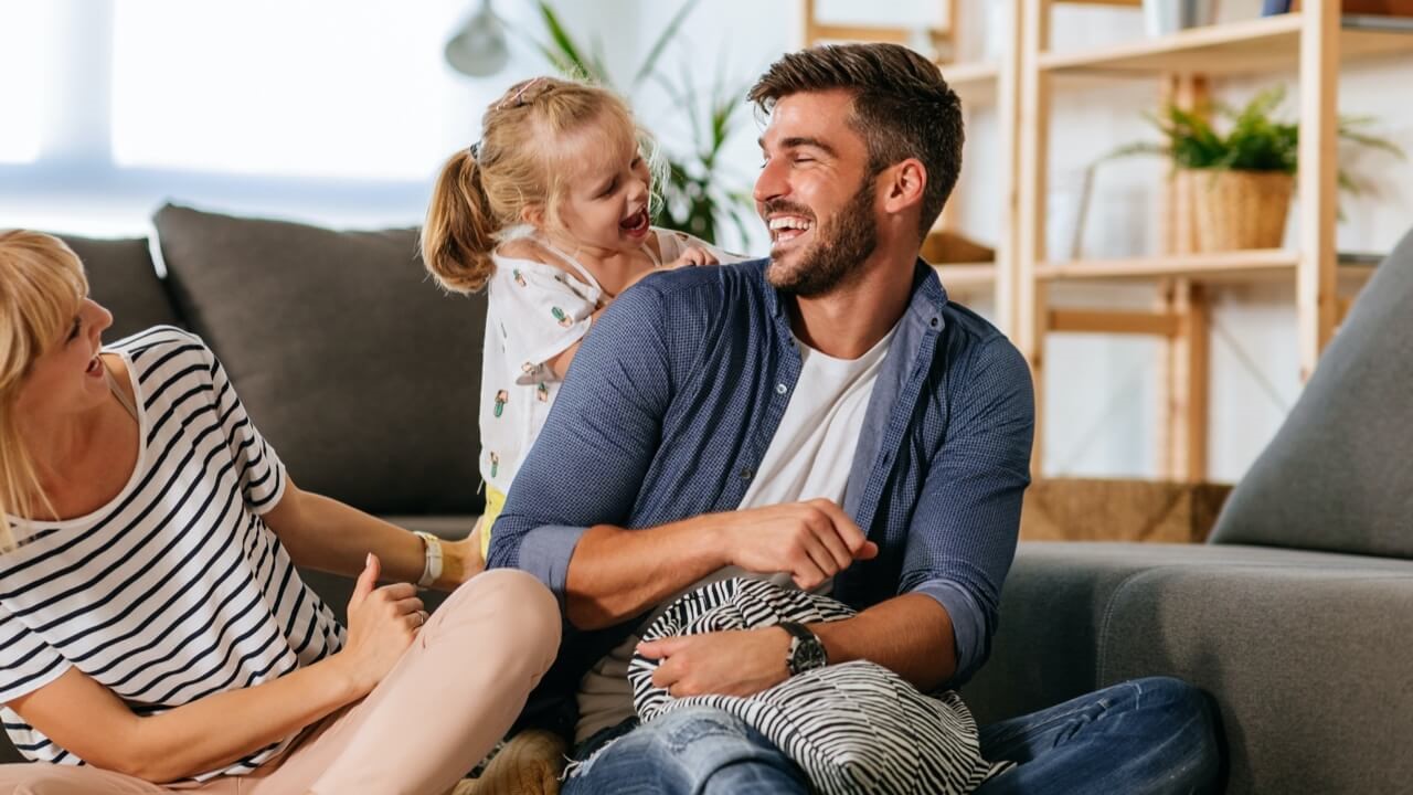 Father laughing with toddler daughter