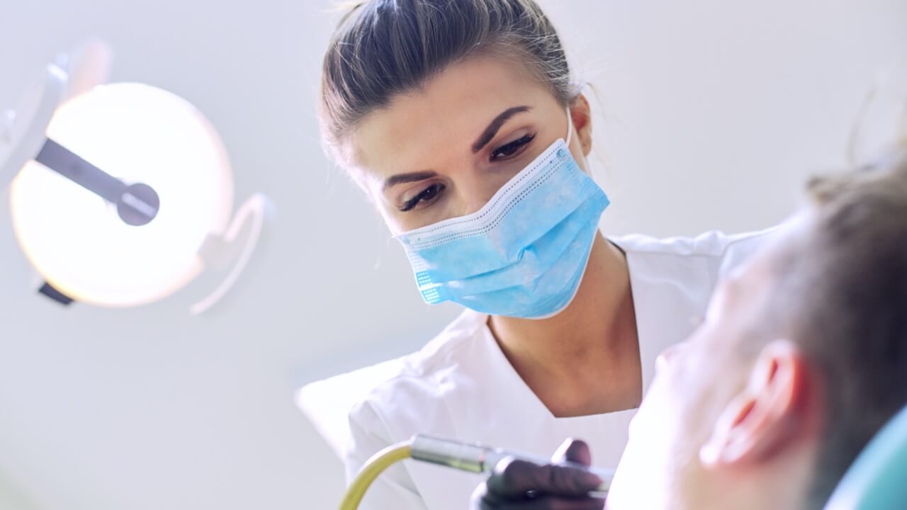 Female dentist treating patient