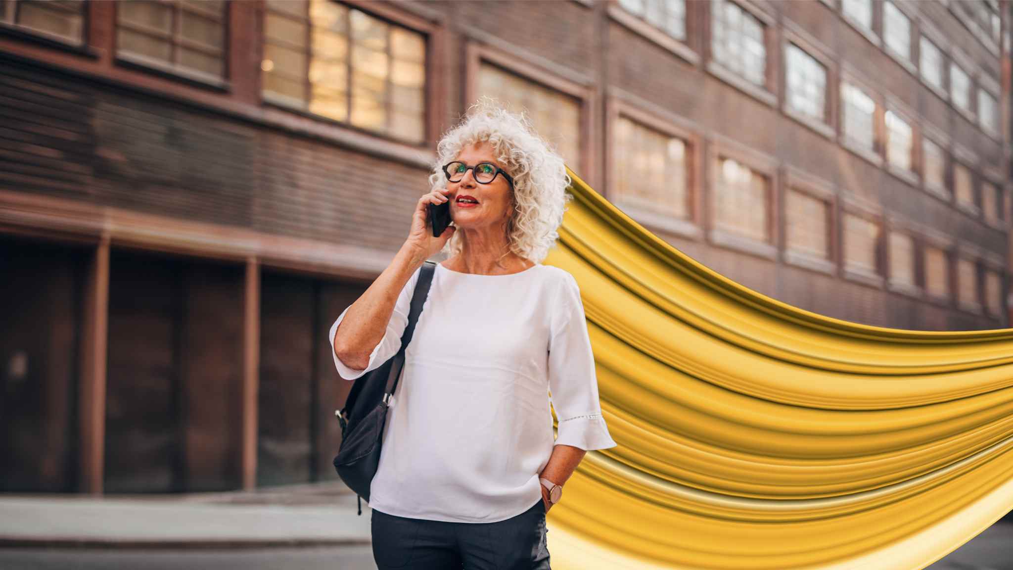 Mature woman on phone with Wesleyan gold whoosh behind her