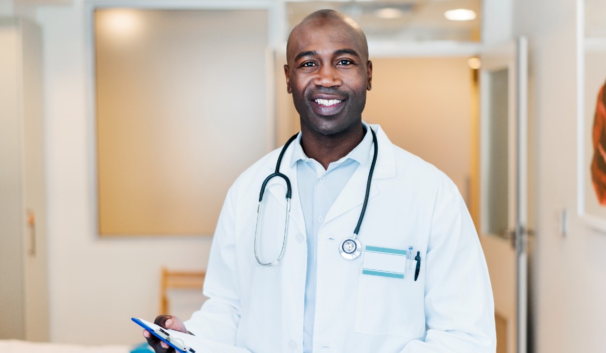 Male medical professional standing in corridor wearing white lab coat