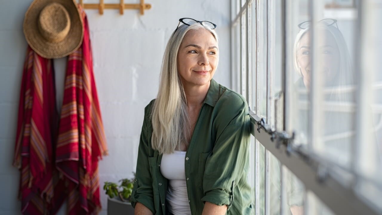 A woman looking out of a window whilst smiling