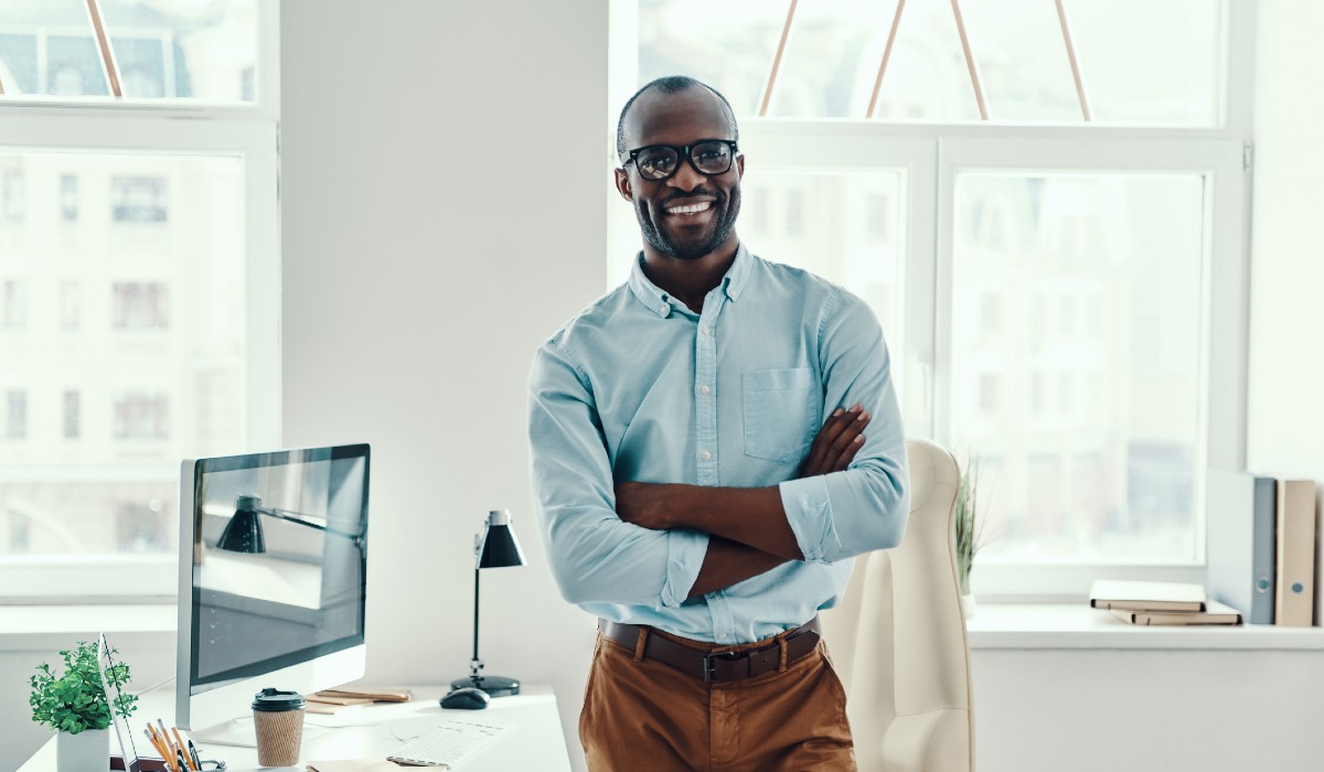 Professional man in office standing by computer