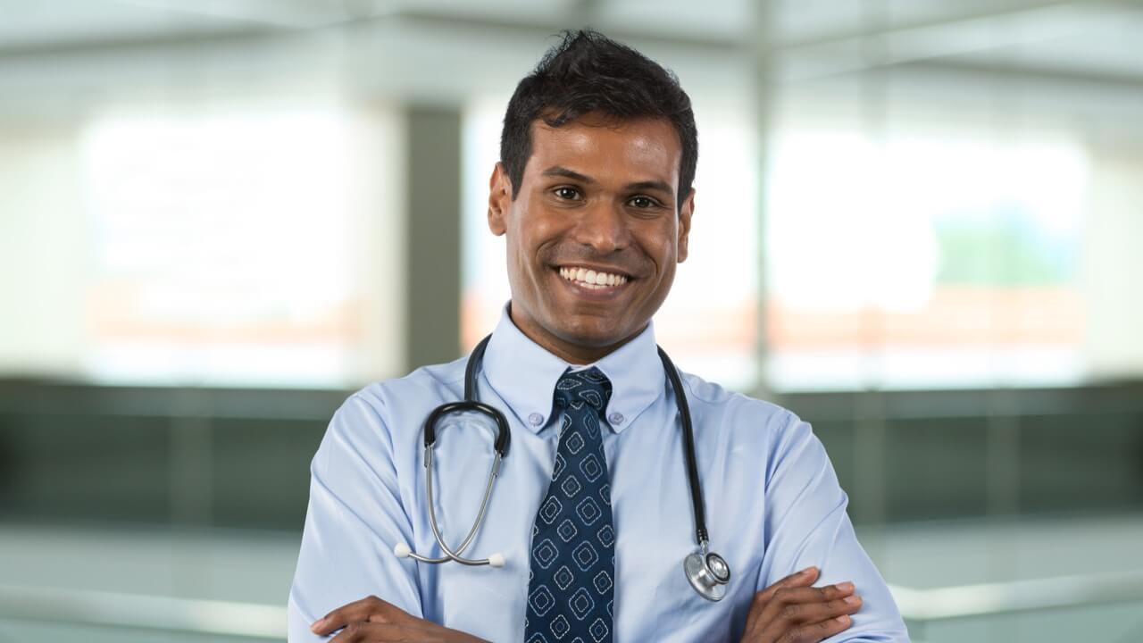 Male doctor smiling wearing stethoscope