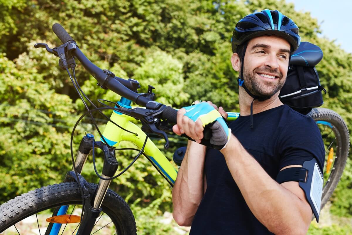 Male cyclist carrying mountain bike