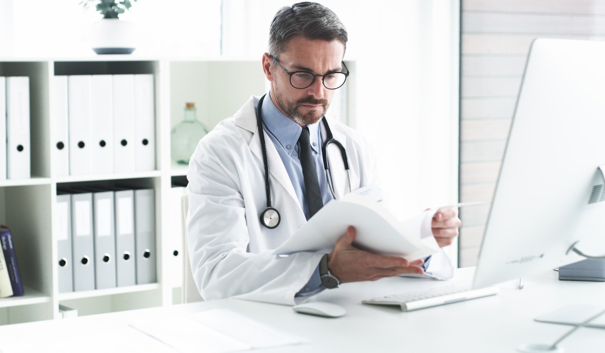 Male doctor in office looking at papers